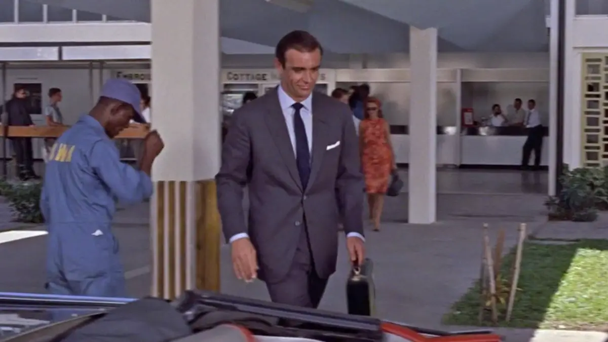 Sean Connery wears a dark grey flannel suit in Dr. No