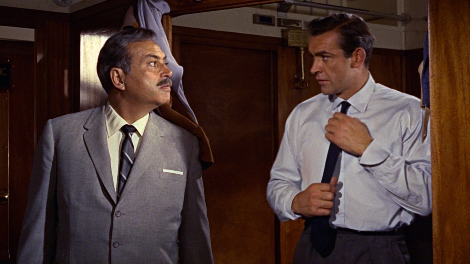 Sean Connery wears a pale blue poplin shirt with his dark grey sharkskin suit in From Russia with Love